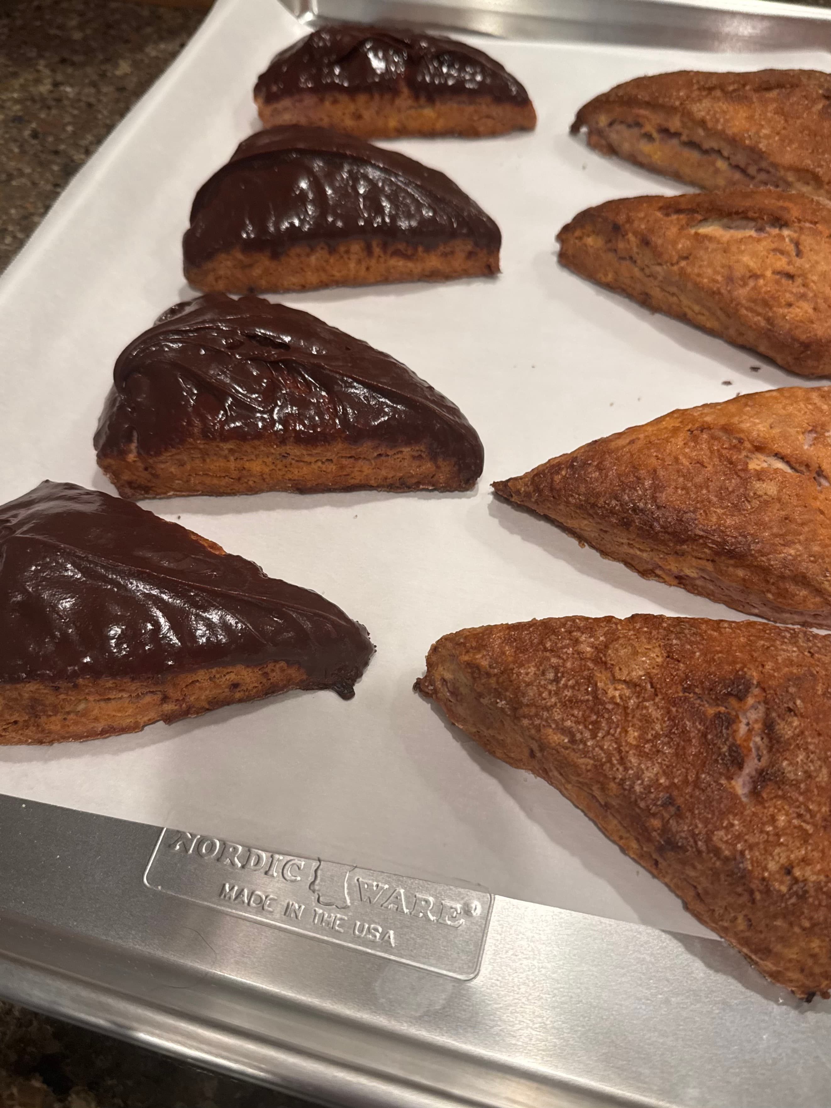 Chocolate-dipped and plain scones on baking sheet